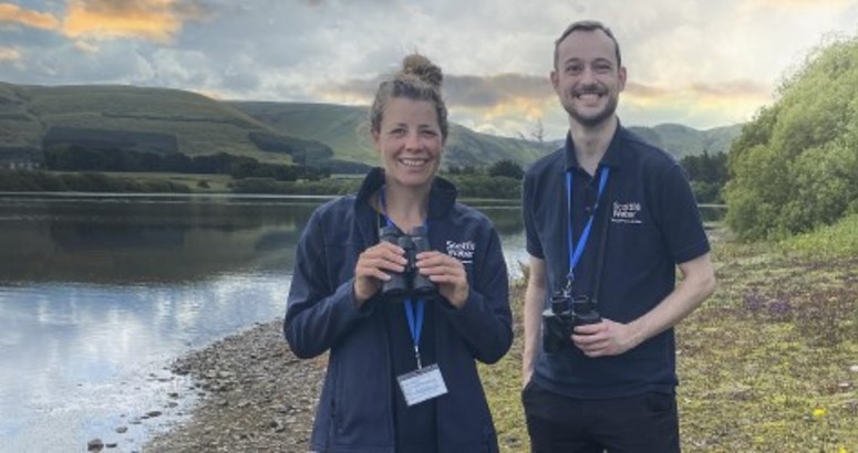 2x Rangers, Helen Rountree on left and Josh Mackin on right, pictured at Gladhouse in front of the reservoir holding binoculours