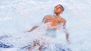 Child floating on its back in a swimming pool