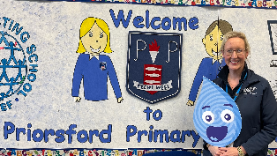 Scottish Water employee in front of welcome sign