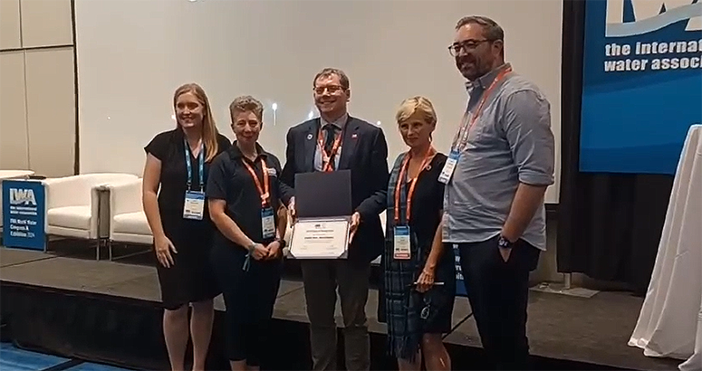 Scottish Water CEO Alex Plant, pictured with four IWA representatives, receives award from climate work at IWA Word Water Congress