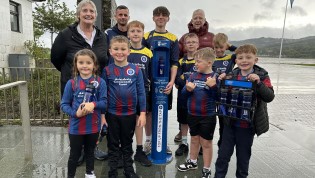 Group of adults and children posing behind brand new water refill station